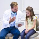 Tannlege forklarer liten jente som har skadet tennene hva som er galt