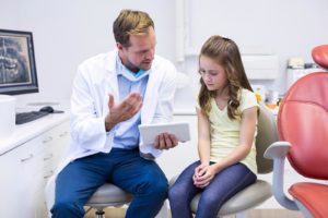 Tannlege forklarer liten jente som har skadet tennene hva som er galt